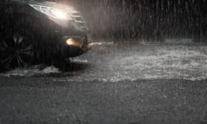 Coche sobre carretera mojada mientras llueve